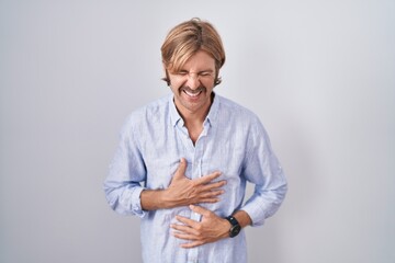 Caucasian man with mustache standing over white background smiling and laughing hard out loud...