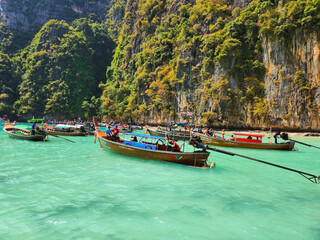 Beautiful blue sea water and boats with tourists in the lagoon of Maya Bay island in Thailand