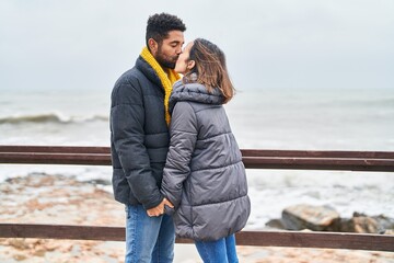 Man and woman couple hugging each other and kissing at seaside