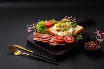 Delicious healthy lunch consisting of bacon, toast, eggs and tomatoes
