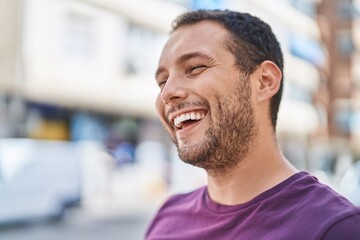 Fototapeta premium Young man smiling confident looking to the side at street