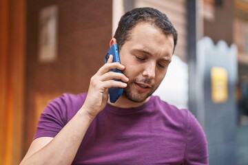 Young man talking on the smartphone at street