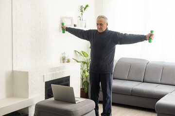Online workout. elderly man doing exercise with online tutorial at home, panorama, free space