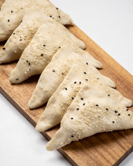 Frozen fresh samsa with black sesame on white background