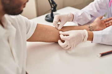 Man and woman wearing doctor uniform having blood analysis at clinic