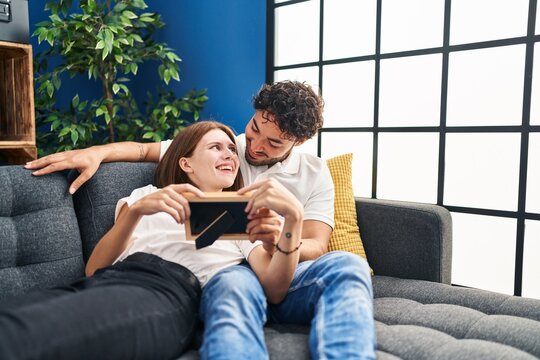 Man and woman smiling confident looking photo at home