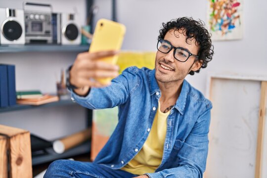Young hispanic man artist make selfie by smartphone at art studio