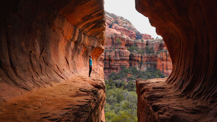 Hiker standing on cliff edge at Subway Cave in Sedona, Arizona