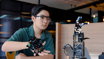 student wearing wireless controller moves robotic hand. Move hand back and forth, the test control...