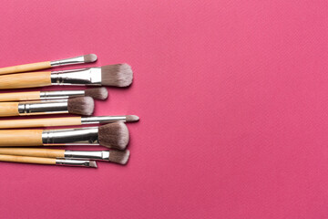 Make up brushes on color background, top view