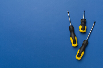 Screwdrivers on color background, top view