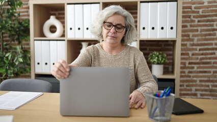 Middle age woman with grey hair business worker using laptop working at office
