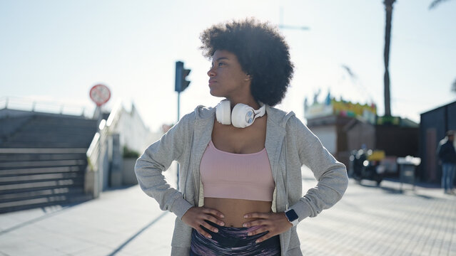 African american woman wearing headphones with relaxed expression at street