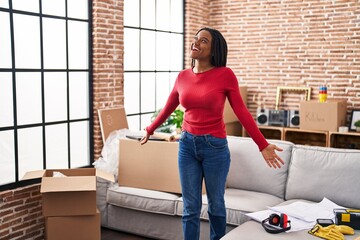 African american woman smiling confident standing with arms open at new home