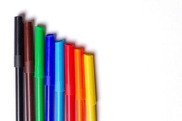 Markers of different colors lie in a row. On a white background.