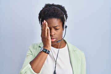 African american woman wearing call center agent headset yawning tired covering half face, eye and...