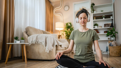 Fototapeta na wymiar One woman sit on the floor practice online guided meditation self care