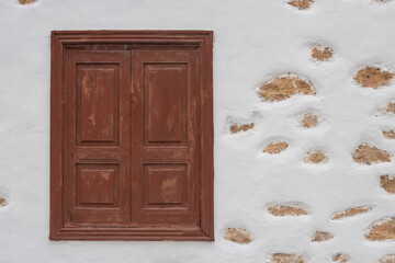 Window and a white facade with stones