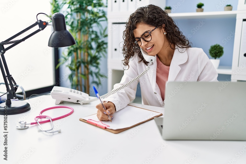 Canvas Prints young latin woman wearing doctor uniform talking on the telephone at clinic