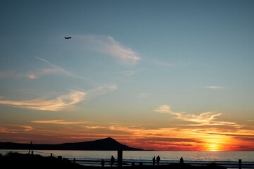 Obraz premium silhouette of several people walking on the beach enjoying the sunset