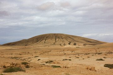 Fototapeta na wymiar A vetical photo of a beautiful view of a mountain in the desert of Fuerteventura