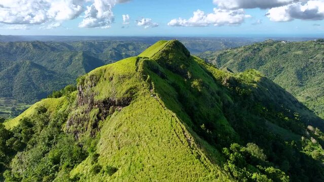 Flying over a Puerto Rican mountain ridge with people on top.