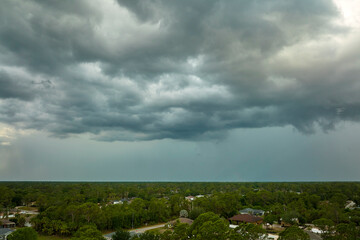 Landscape of dark ominous clouds forming on stormy sky before heavy thunderstorm over rural town...