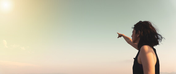 Woman pointing sunny empty blue sky. High resolution photo image can be used as large printed...
