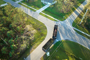 Top view of Hurricane Ian special aftermath recovery dump truck picking up tree branches debris from Florida rural streets. Dealing with consequences of natural disaster © bilanol