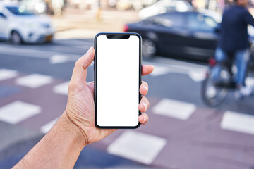 Man holding smartphone showing white blank screen at street