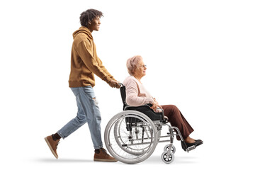 Full length profile shot of an african american young man pushing an elderly woman in a wheelchair