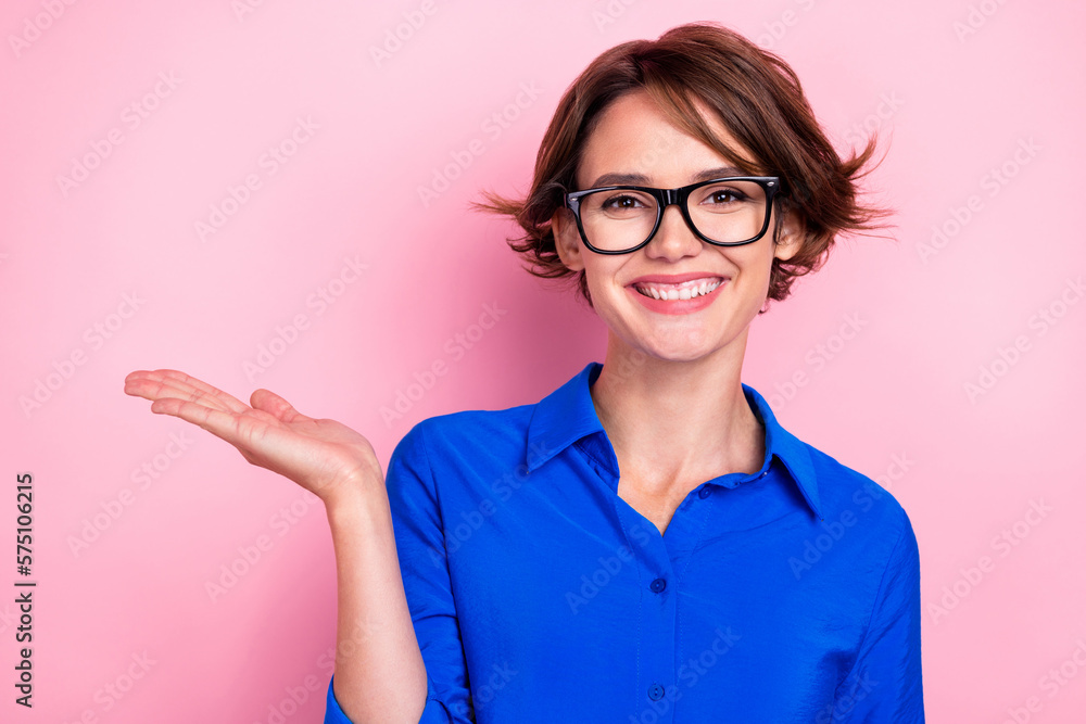 Wall mural photo of cheerful nice person arm palm hold demonstrate empty space isolated on pink color backgroun