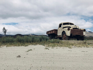 The beauty of rust: an old car under a cloudy sky