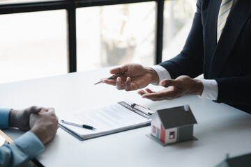 Real estate agents explain models of housing estates in projects to elaborate to clients, explaining and presenting information about homes and purchasing loans. Real estate trading concept.