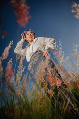 Asian beautiful young lady at the outdoors flowered field. (against plongée)