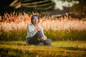 Asian young lady sitting at the outdoors flowered field.