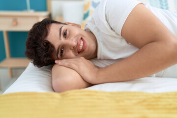 Non binary man smiling confident lying on bed at bedroom