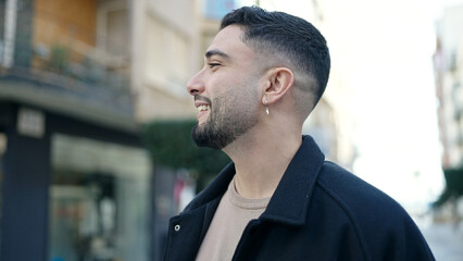Young arab man smiling confident looking to the side at street