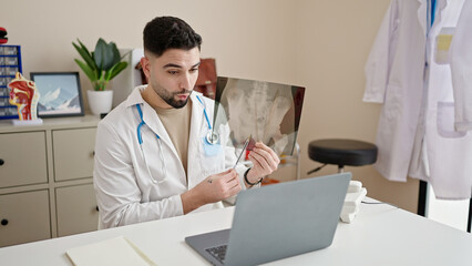 Young arab man doctor looking xray having video call at clinic