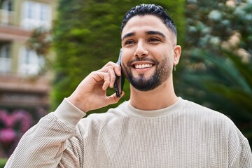 Young arab man smiling confident talking on the smartphone at park