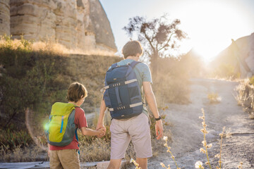 Father and son tourists on background of Unique geological formations in Love Valley in Cappadocia, popular travel destination in Turkey. Traveling with children in Turkey concept