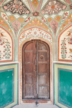Old wooden door  with colorful symetrical floral ornament in Amber Palace in Jaipur, Rajasthan, India