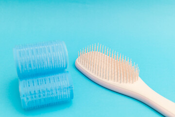 Large hair curlers on blue background, monochrome