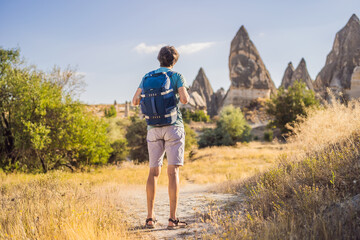 Fototapeta premium Man tourist on background of Unique geological formations in Love Valley in Cappadocia, popular travel destination in Turkey