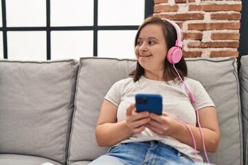 Down syndrome woman watching video on smartphone at home