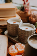 handmade scented candles, coffee, books and tangerines for the New Year. Cozy atmosphere of Christmas at home