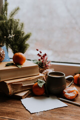 an empty postcard next to books and tangerines. Plans and dreams for the new year. space for text
