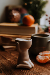 handmade scented candles, coffee, books and tangerines for the New Year. Cozy atmosphere of Christmas at home