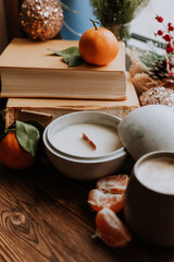 handmade scented candles, coffee, books and tangerines for the New Year. Cozy atmosphere of Christmas at home