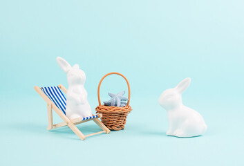 Bunny or rabbit sitting on lounge chair, basket with sea stars, easter holiday, vacation by the sea